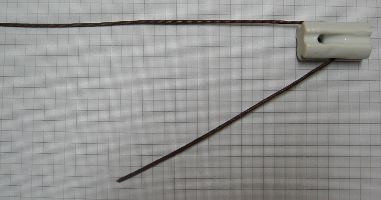 Photo#1. Feed antenna wire through the strain insulator with sufficient tail length to reach the feed line connection